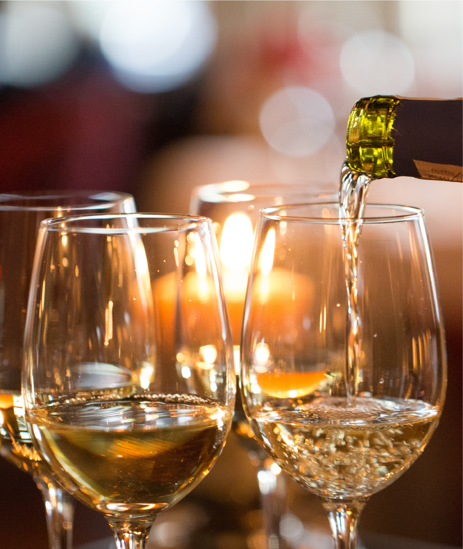 Des verres a vins en train d'être remplis de vin blanc